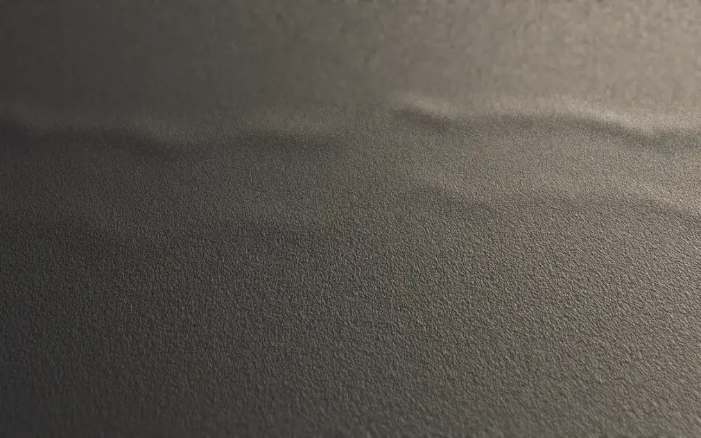 A loose wave running across wall-to-wall carpet, its crest caught by side light