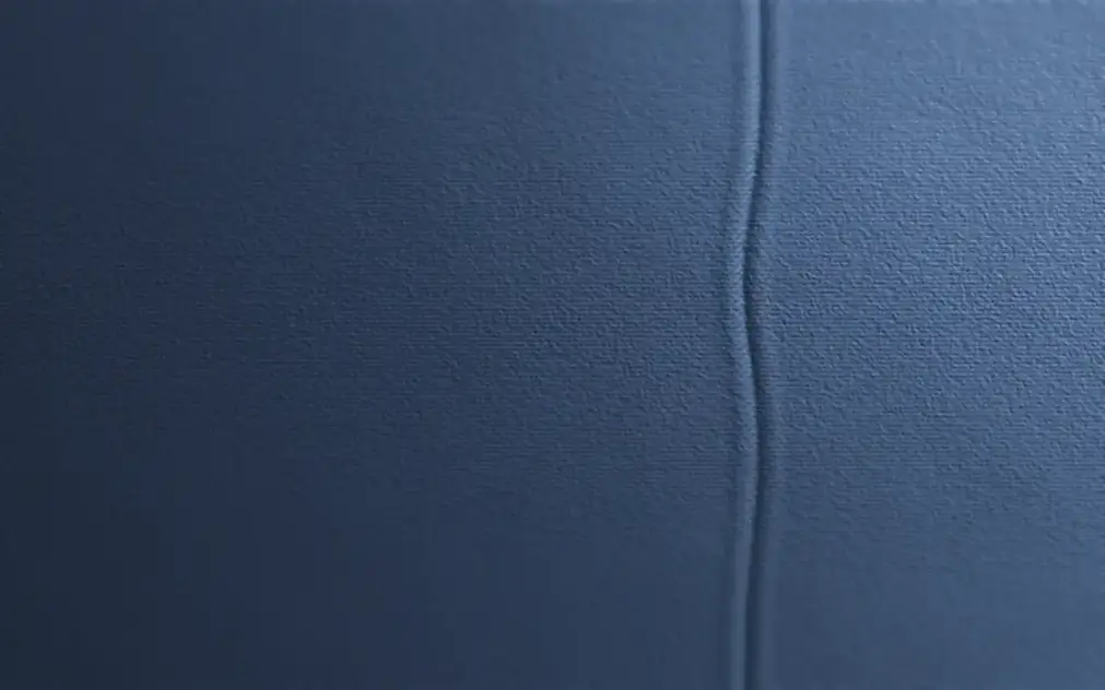Close view of a blue upholstery weave running up to a sewn seam